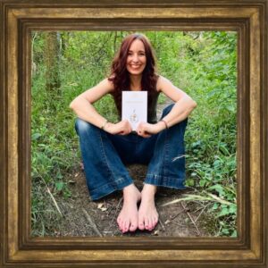 Iris Feige mit einem ausgedruckten Human Design EBook im Wald